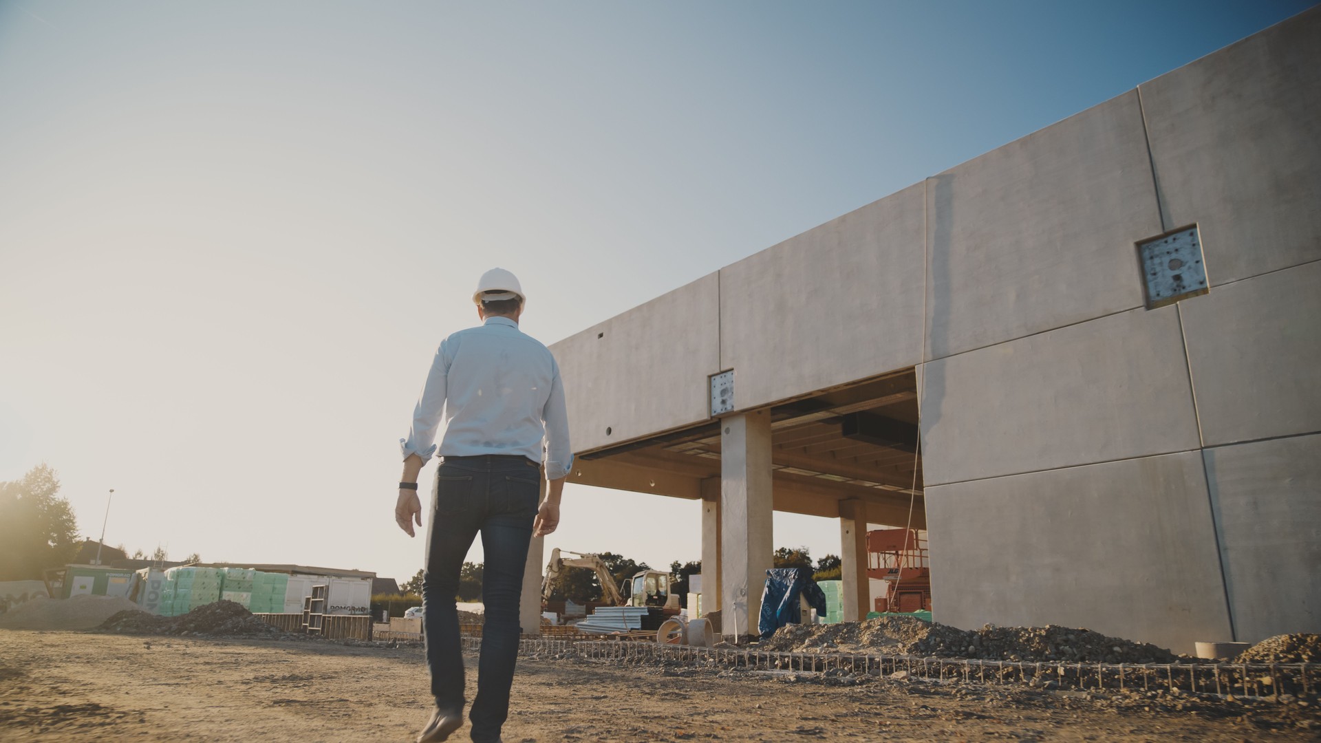 Male project manager walking towards under development building